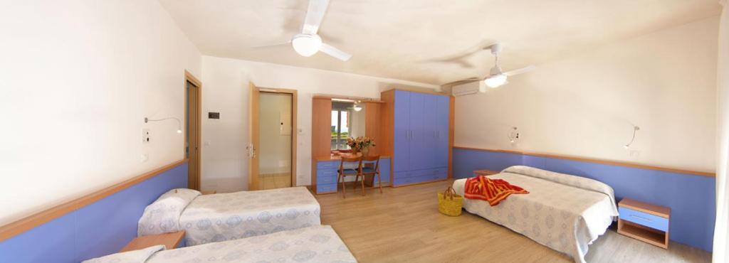 Cette grande chambre comprend deux lits et une table. dans l'établissement Hotel Bertha Fronte Mare, à Lido di Jesolo