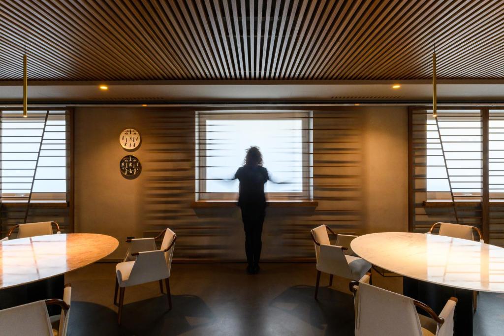 une femme debout dans une pièce donnant par une fenêtre dans l'établissement Hotel Royal Paestum, à Paestum 107 autres photos