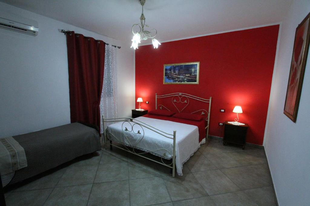- une chambre aux murs rouges et un lit dans un dortoir dans l'établissement Villa Luisa villa con piscina e Vasca Idromassaggio vicino Otranto, à Carpignano Salentino 34 autres photos