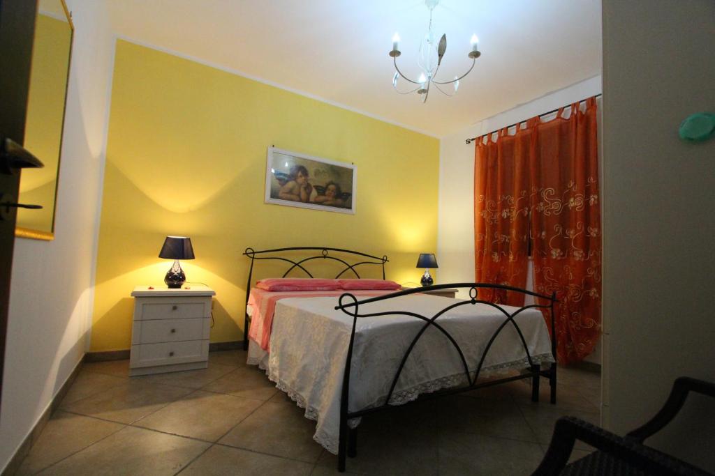 une chambre avec un lit et un lustre dans l'établissement Villa Luisa villa con piscina e Vasca Idromassaggio vicino Otranto, à Carpignano Salentino