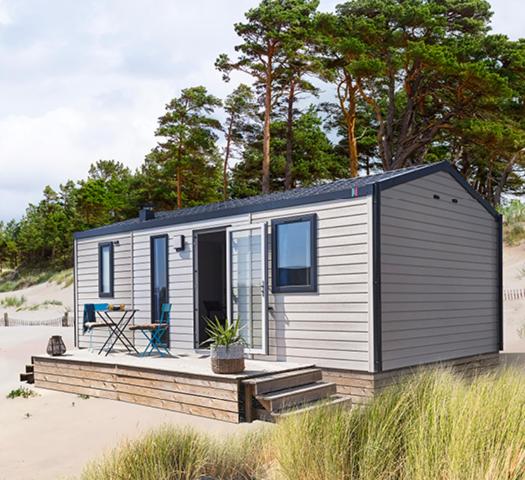 une petite maison assise sur la plage sur le sable dans l'établissement Domaine du Blanc Pignon, à La Calotterie