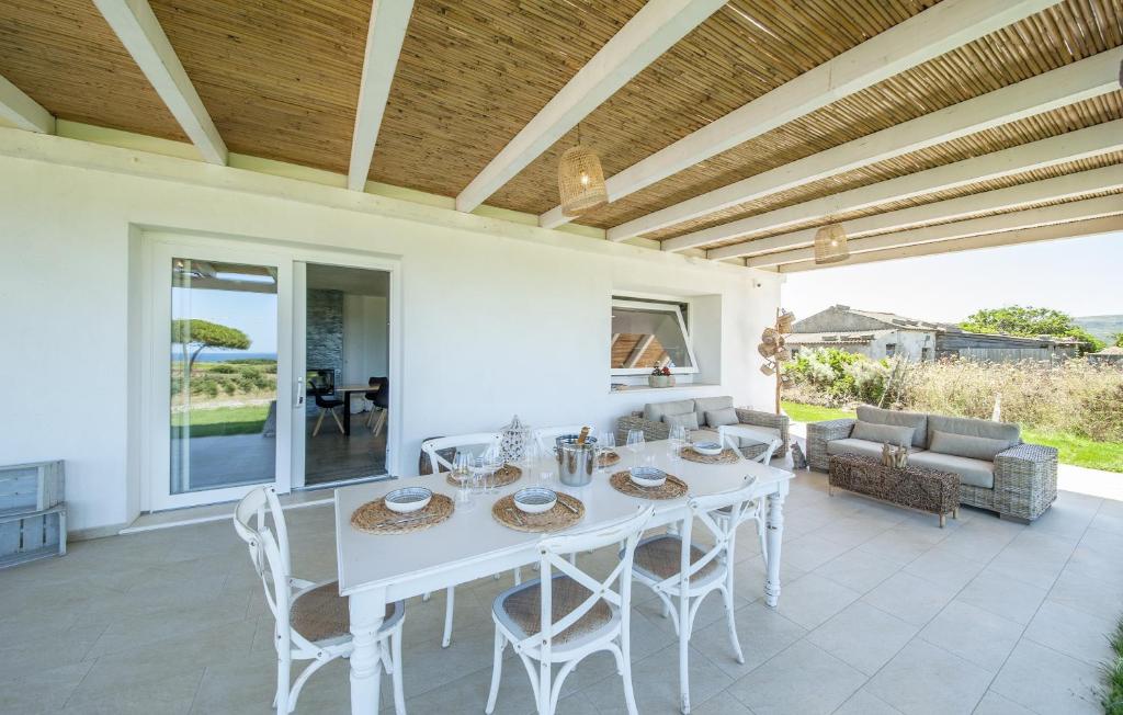une table blanche et des chaises sur une terrasse dans l'établissement Bellimpiazza - Villa vista mare con piscina, à Sorso
