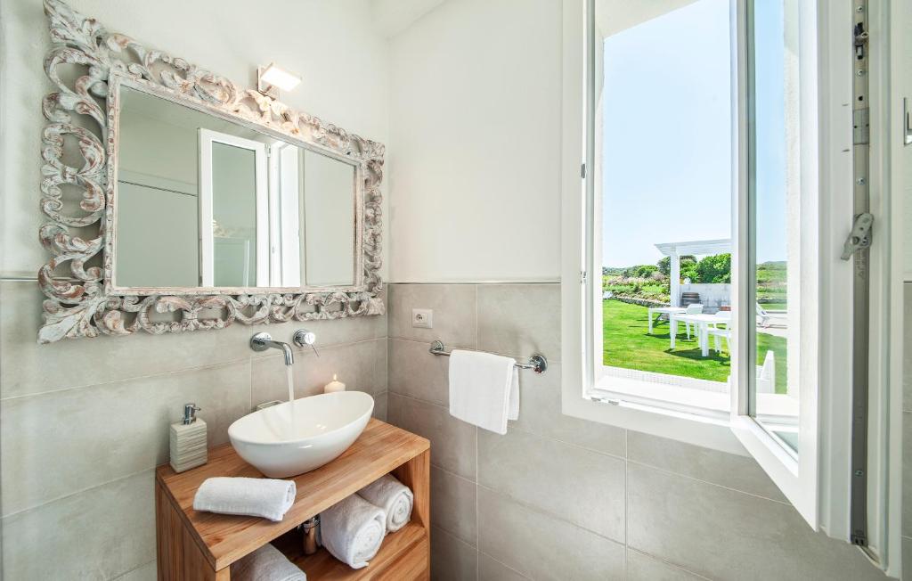 une salle de bain avec un lavabo et un miroir dans l'établissement Bellimpiazza - Villa vista mare con piscina, à Sorso