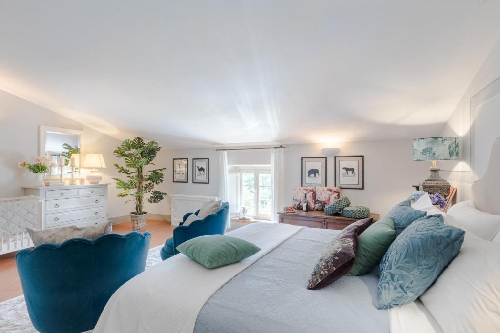- une chambre avec un grand lit et des chaises bleues dans l'établissement Fattoria Camigliano, Luxury Farmhouse with Pool inside a Wine Estate, à Capannori