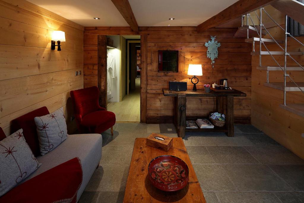un salon avec un canapé et une table dans l'établissement Hôtel La Ferme du Chozal, Chalet de tradition, à Hauteluce
