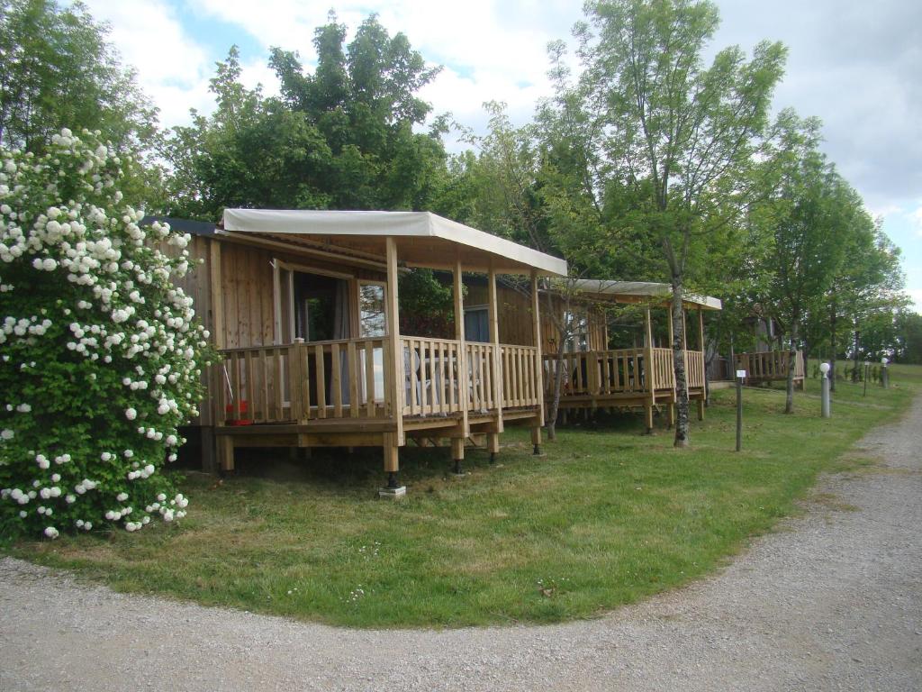 une rangée de cottages en bois dans un parc dans l'établissement CAMPING LES GRAVES - Cabane TITHOME, à Saint-Pierre-Lafeuille