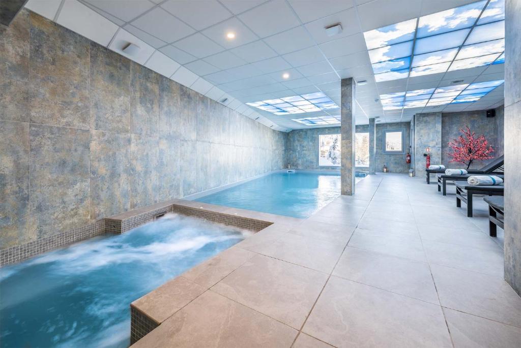 une grande piscine dans une chambre avec piscine dans l'établissement Madame Vacances Hôtel & Spa Le Mottaret, à Méribel