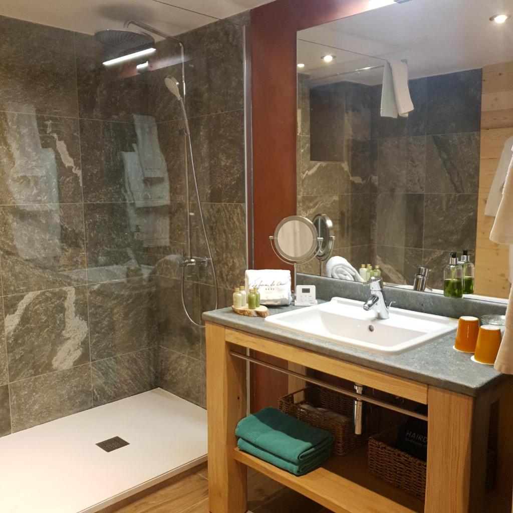 une salle de bain avec un lavabo et une douche dans l'établissement Hôtel La Ferme du Chozal, Chalet de tradition, à Hauteluce
