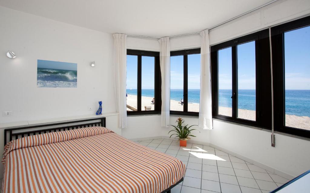 - une chambre avec un lit et une vue sur la plage dans l'établissement Residence Le Dune Club, à Varigotti