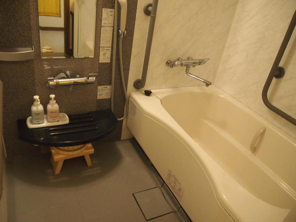 une salle de bain avec une baignoire, des toilettes et un lavabo dans l'établissement Oyado Koto No Yume, à Takayama