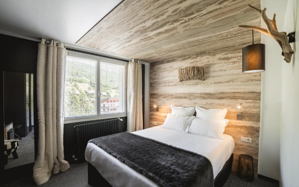 une chambre d'hôtel avec un lit et une fenêtre dans l'établissement Rock Noir & Spa, à La Salle Les Alpes