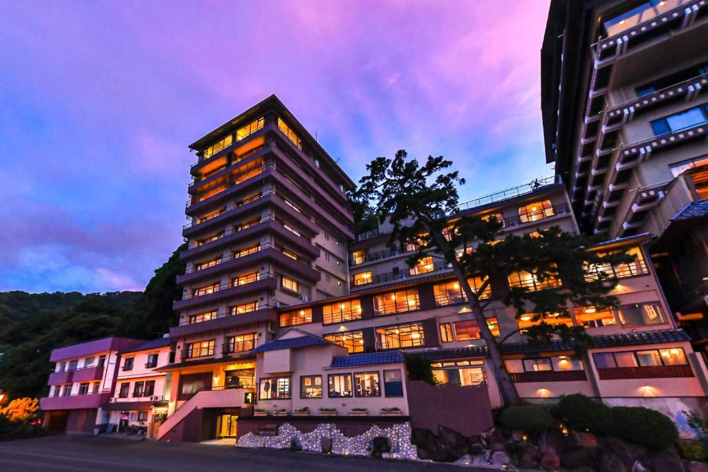 un grand bâtiment avec de nombreuses fenêtres la nuit dans l'établissement Hokkawa Onsen Hotel, à Higashiizu