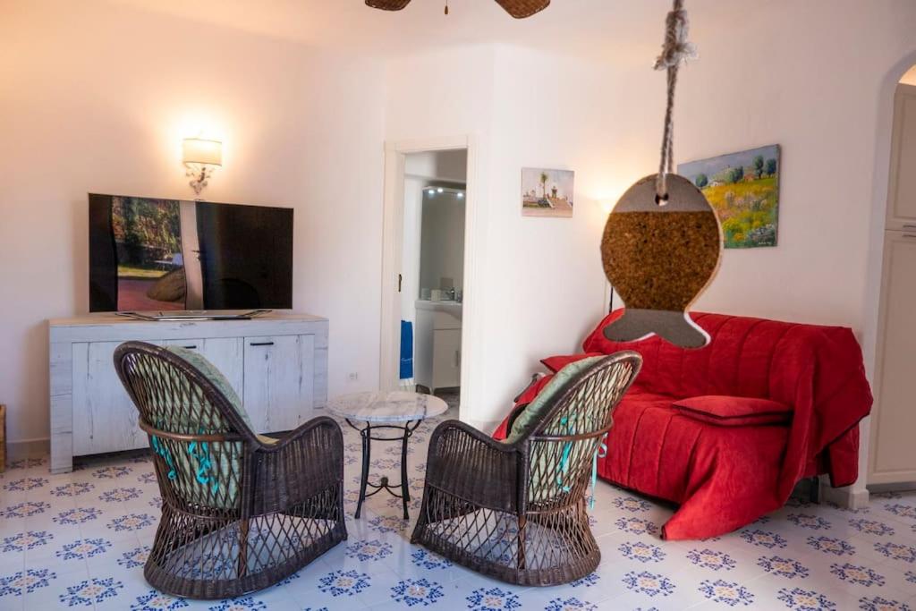 - un salon avec un canapé et des fauteuils rouges dans l'établissement Villa Conchiglia blu con piscina, à Ischia