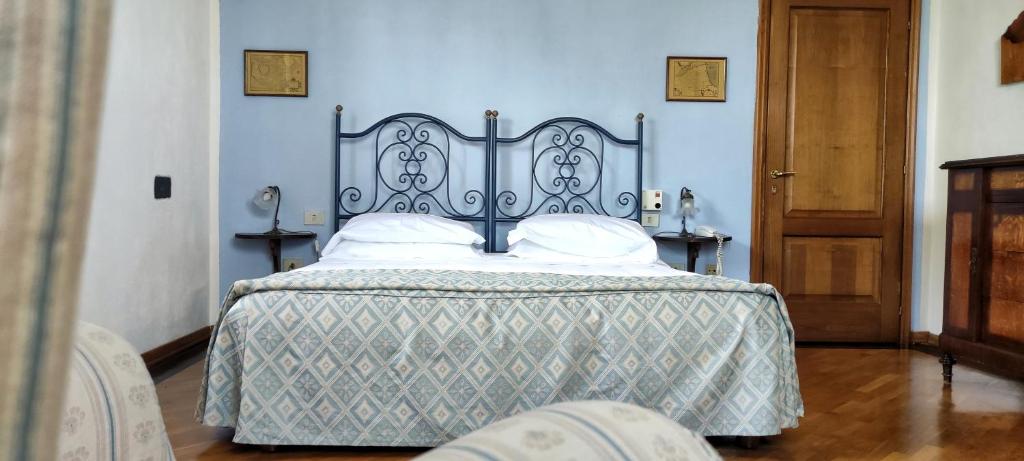 Ce lit se trouve dans une chambre dotée d'un mur bleu. dans l'établissement Montebelli Agriturismo & Country Hotel, à Caldana