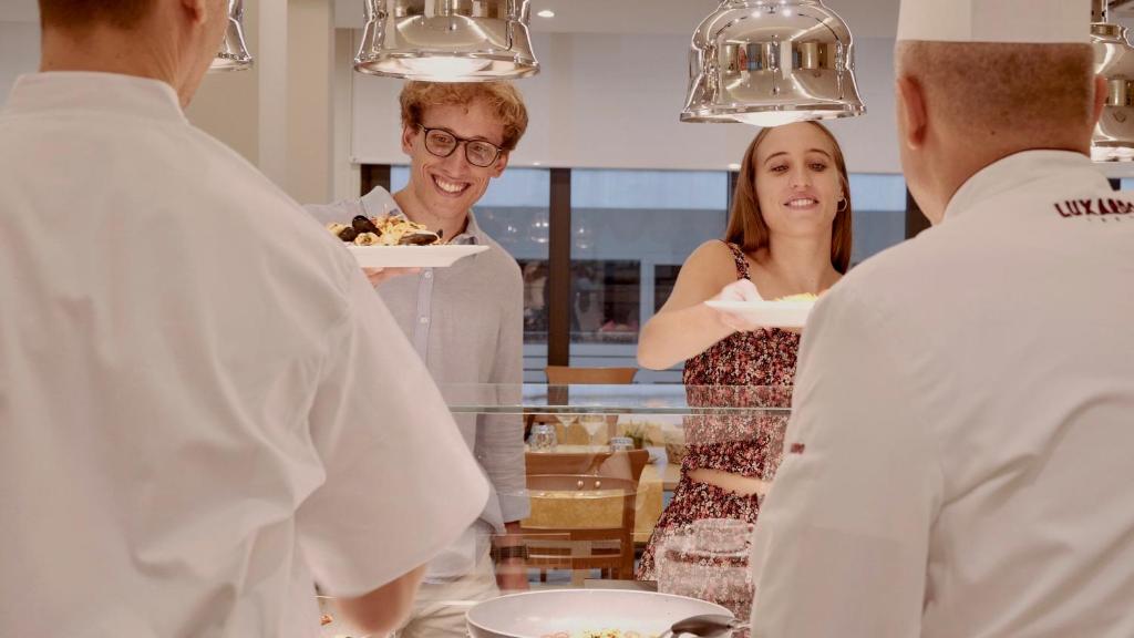un homme et une femme debout dans une cuisine préparant la nourriture dans l'établissement Hotel Principe, à Cattolica 132 autres photos