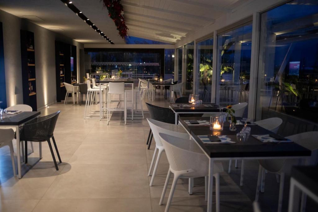 un restaurant avec des tables et des chaises et une vue sur la ville dans l'établissement Hotel Quadrifoglio, à Pontecagnano