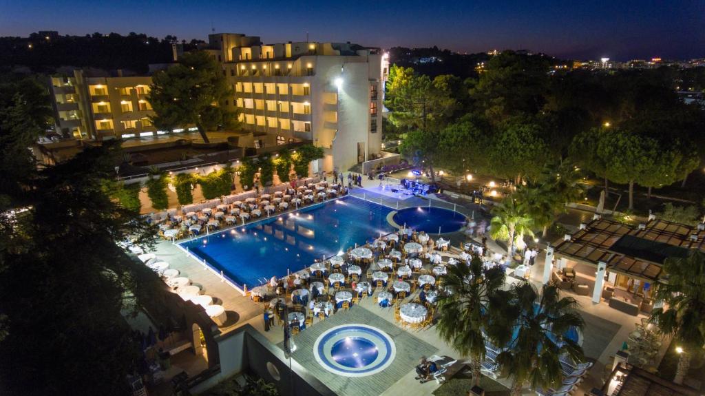 une vue aérienne d'un hôtel avec piscine la nuit dans l'établissement Pizzomunno Vieste Palace Hotel, à Vieste