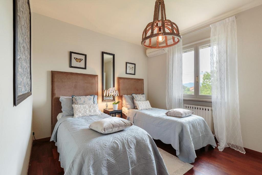 une chambre avec deux lits et un lustre dans l'établissement Villa Annalisa, à Lucques