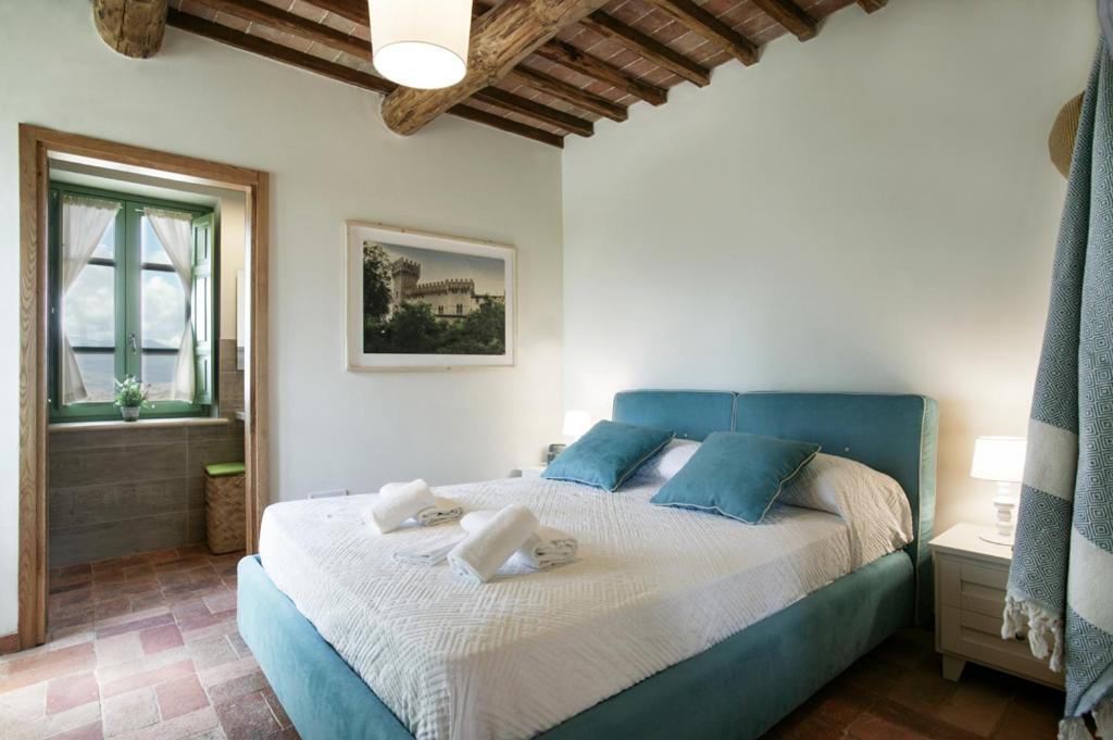une chambre avec un lit bleu avec des serviettes dessus dans l'établissement Colle Galli, à Acquapendente 39 autres photos