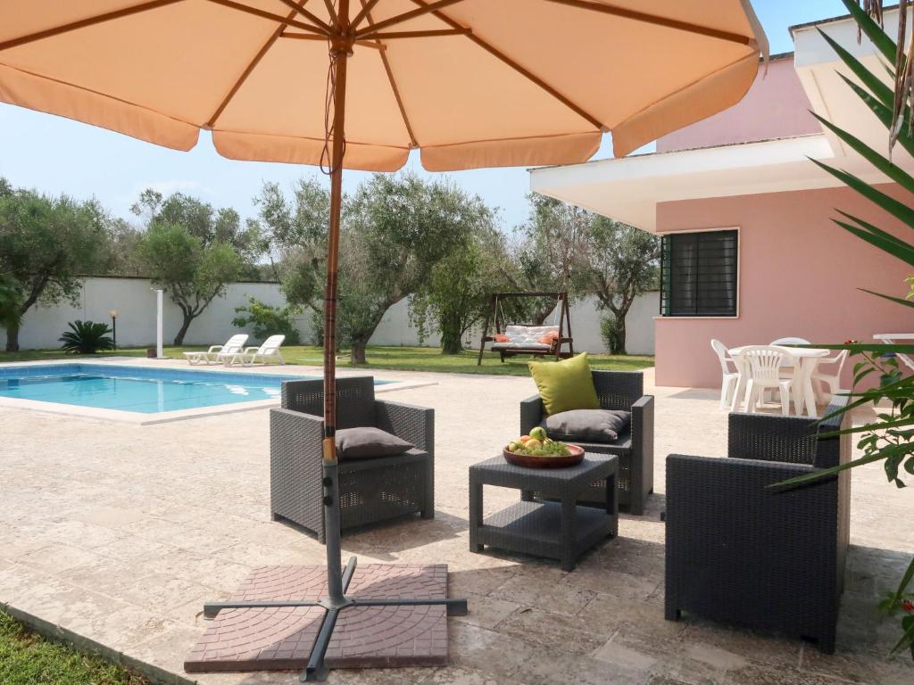 un patio avec un parasol et des chaises et une piscine dans l'établissement Villa Giusy by Interhome, à Martignano