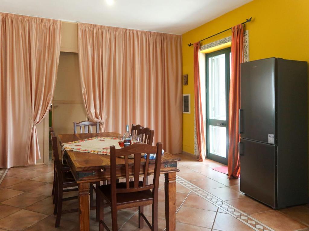 une salle à manger avec une table et un réfrigérateur dans l'établissement Villa Giusy by Interhome, à Martignano