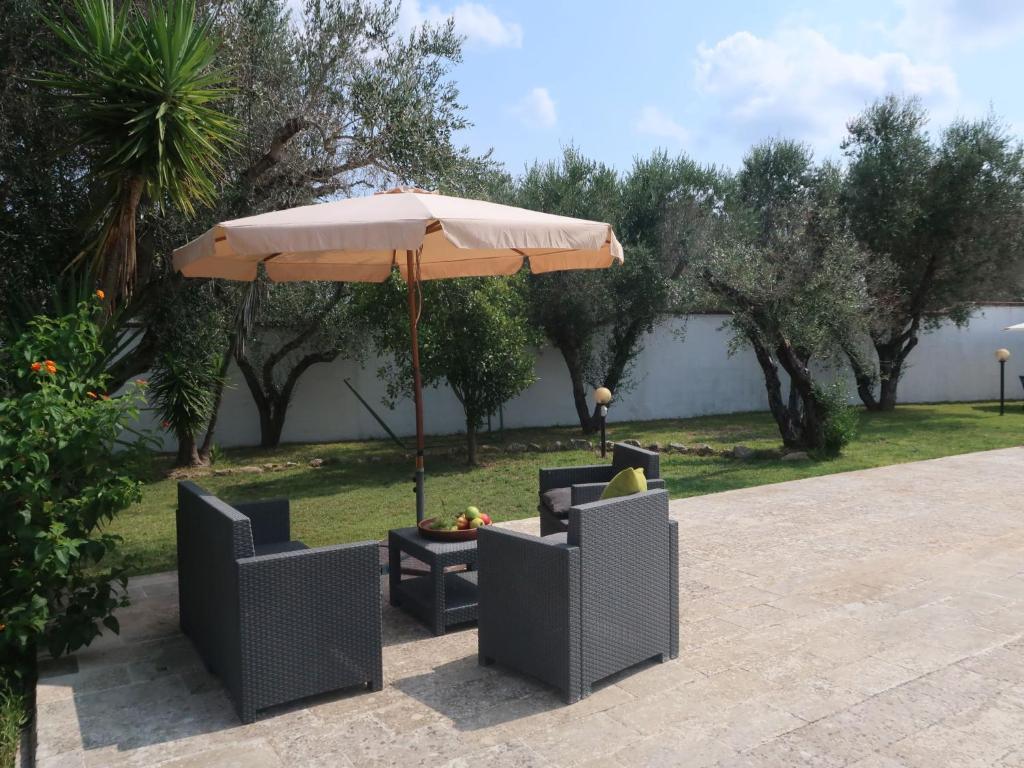 - une table et des chaises sous un parasol sur la terrasse dans l'établissement Villa Giusy by Interhome, à Martignano