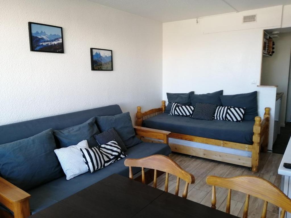 un salon avec un canapé bleu et des chaises dans l'établissement Studio 4 personnes au pied des pistes, au Corbier
