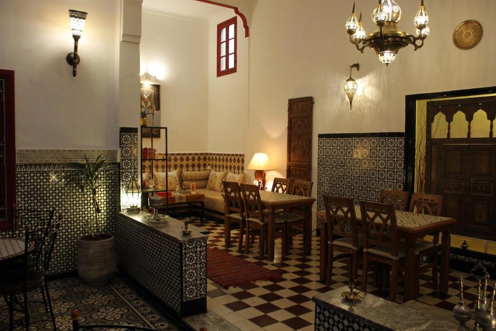 un salon avec un canapé, une table et des chaises dans l'établissement Riad Meftaha, à Rabat
