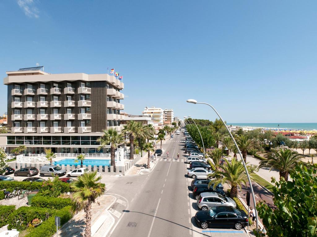 une rue de la ville avec des voitures garées dans un parking dans l'établissement Hotel Eden, à Alba Adriatica