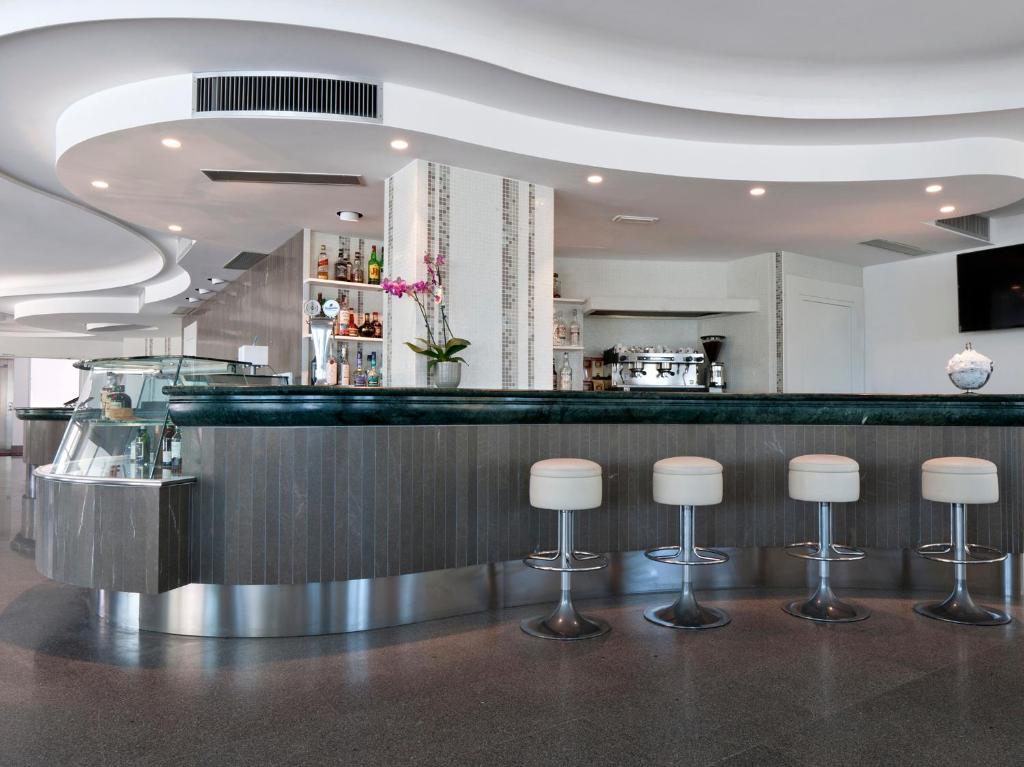 un bar avec des tabourets dans un restaurant dans l'établissement Hotel Eden, à Alba Adriatica
