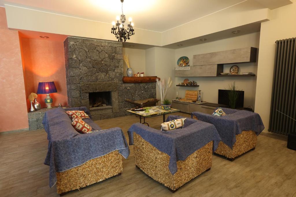 - un salon avec trois canapés et une cheminée dans l'établissement Casa delle foglie, à San Giovanni la Punta