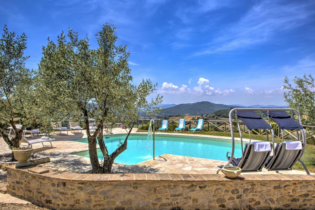 - une piscine avec 2 chaises longues dans un complexe dans l'établissement Villa San Lorenzo - Hilltop Villa With Private Pool, Jacuzzi & AirCO, à Montone