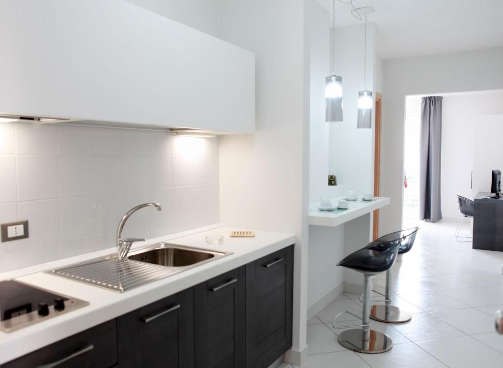 une cuisine avec un évier et un tabouret noir dans l'établissement Brezza Di Grecale, à Trapani