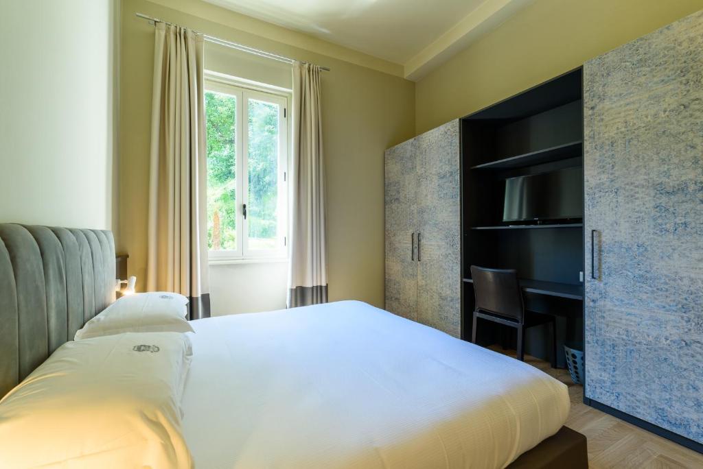 une chambre avec un lit blanc et un bureau dans l'établissement Hotel Villa Paradiso, à Arona 31 autres photos