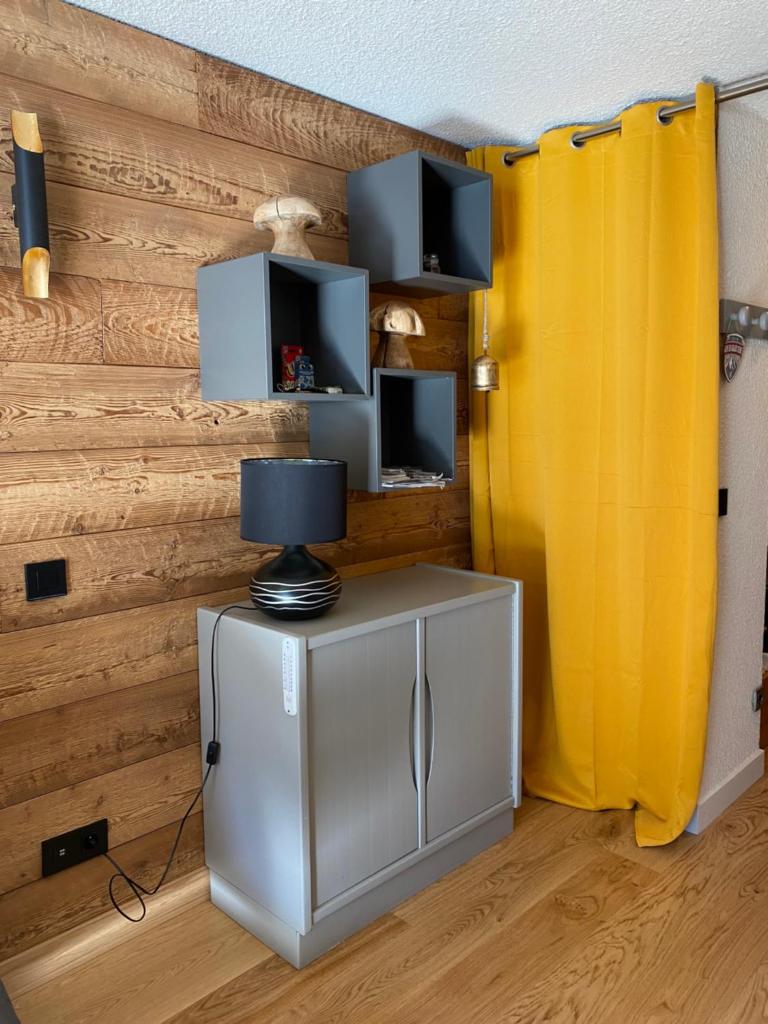 une chambre avec un rideau jaune et une table avec une lampe dans l'établissement Superbe studio de montagne, au pied des pistes de ski, classé 3 étoiles, à La Morte