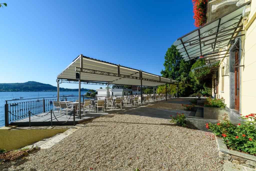 d'une terrasse avec des tables et des chaises au bord de l'eau. dans l'établissement Hotel Villa Paradiso, à Arona