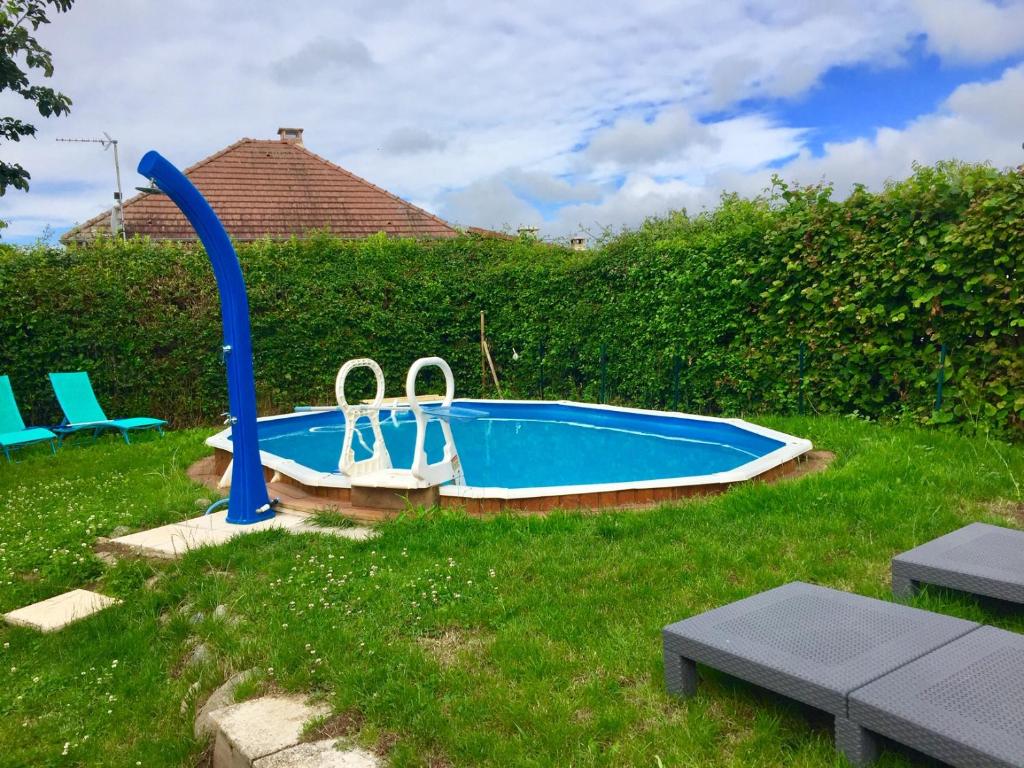 une petite piscine dans l'herbe à côté d'une haie dans l'établissement Yourte mongole, à Huriel