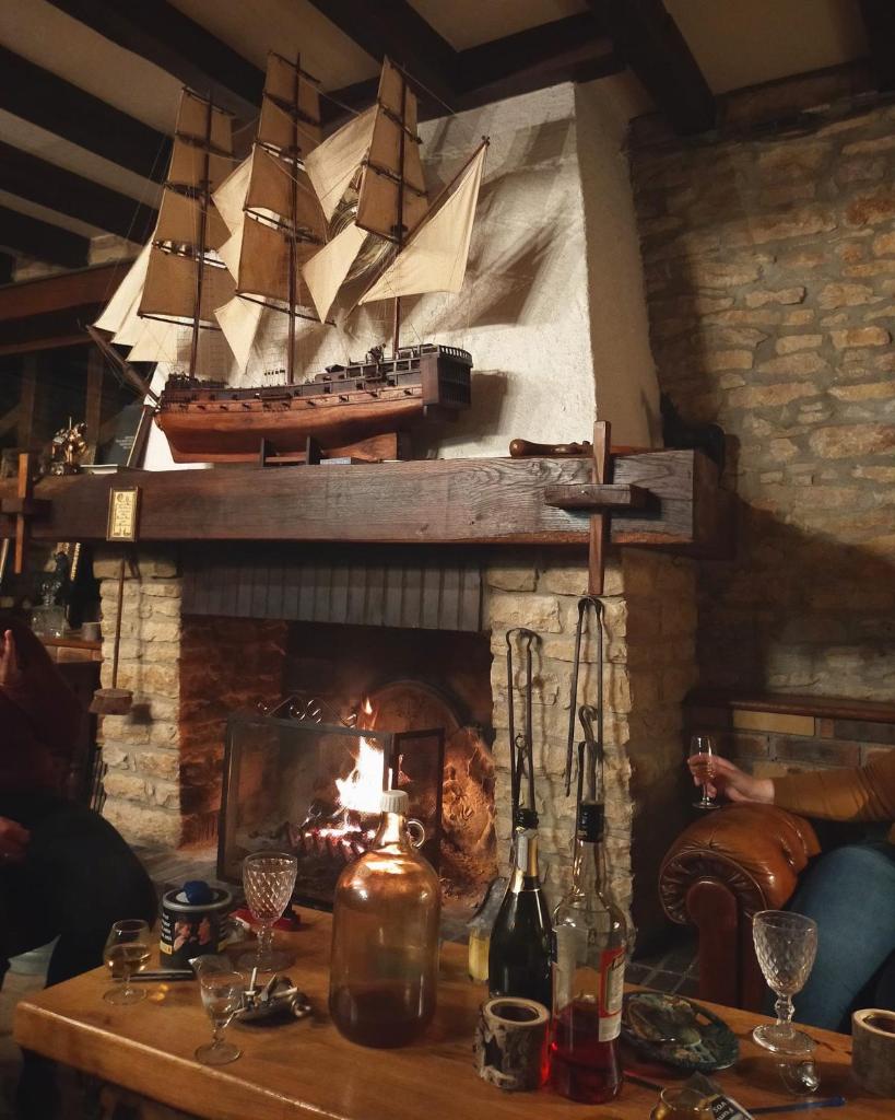 une chambre avec une cheminée et un bateau pirate sur le mur dans l'établissement Gîte du ru d ausson, à Avrigny