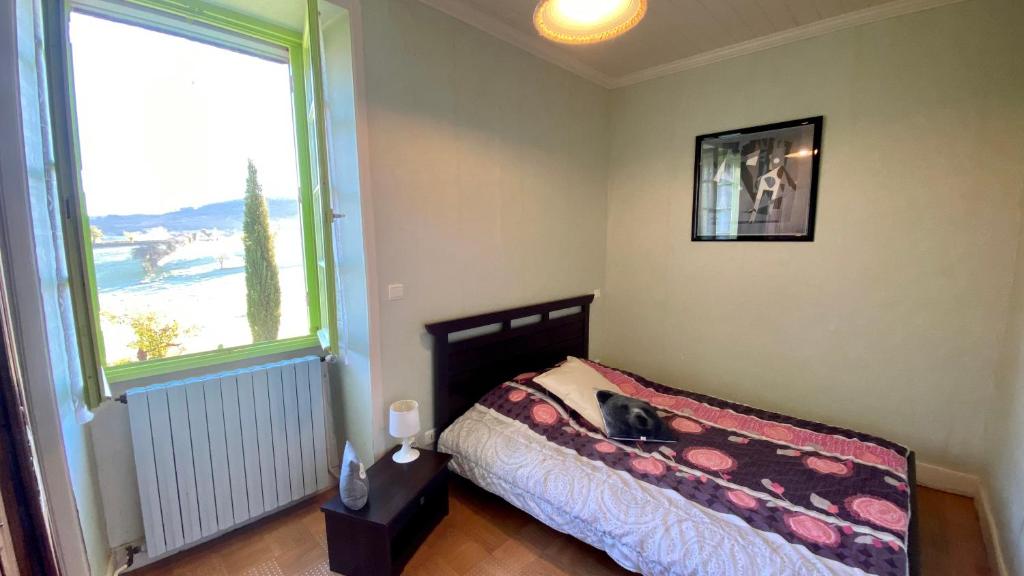 une chambre avec un lit et une grande fenêtre dans l'établissement Maison coconing piscine couverte chauffée, à Mayrinhac-Lentour 15 autres photos