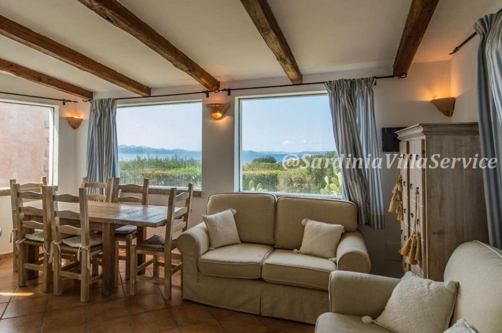 un salon avec un canapé, une table et des chaises dans l'établissement Villa Cala Granu - Porto Cervo, à Porto Cervo