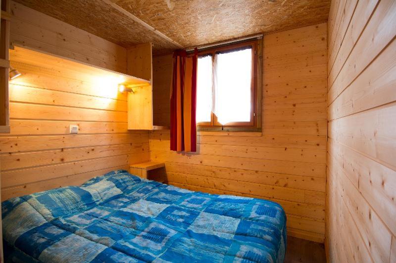 une chambre avec un lit dans une pièce en bois dans l'établissement Camping maeva Escapades Le Domaine Aramis, à Marsan 37 autres photos