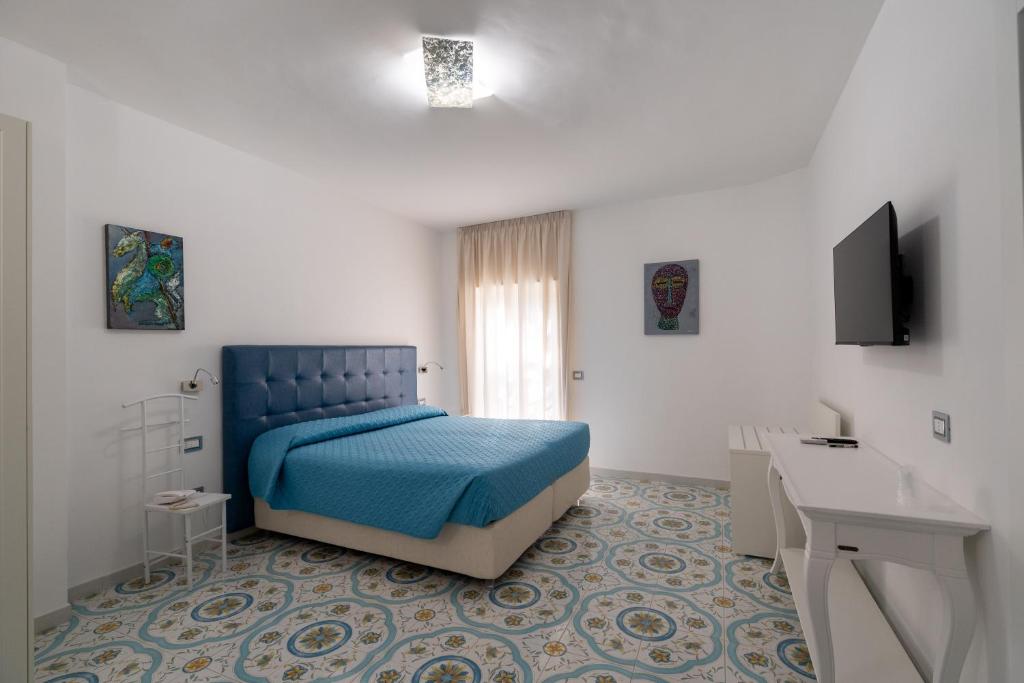 - une chambre avec un lit bleu et un bureau dans l'établissement Park Hotel Villa Maria, à San Menaio