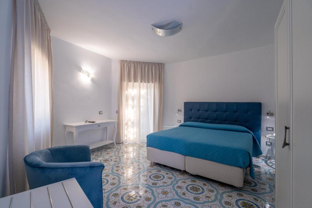une chambre avec un lit bleu et une chaise dans l'établissement Park Hotel Villa Maria, à San Menaio 55 autres photos