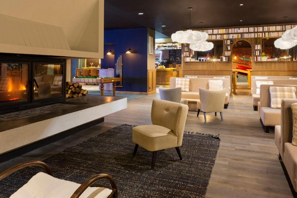 un restaurant avec une cheminée, des chaises et des tables dans l'établissement RockyPop Flaine Hotel & Spa, à Flaine