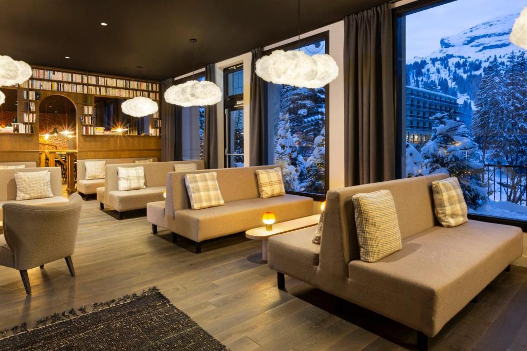 - un hall avec des canapés, des chaises et une grande fenêtre dans l'établissement RockyPop Flaine Hotel & Spa, à Flaine
