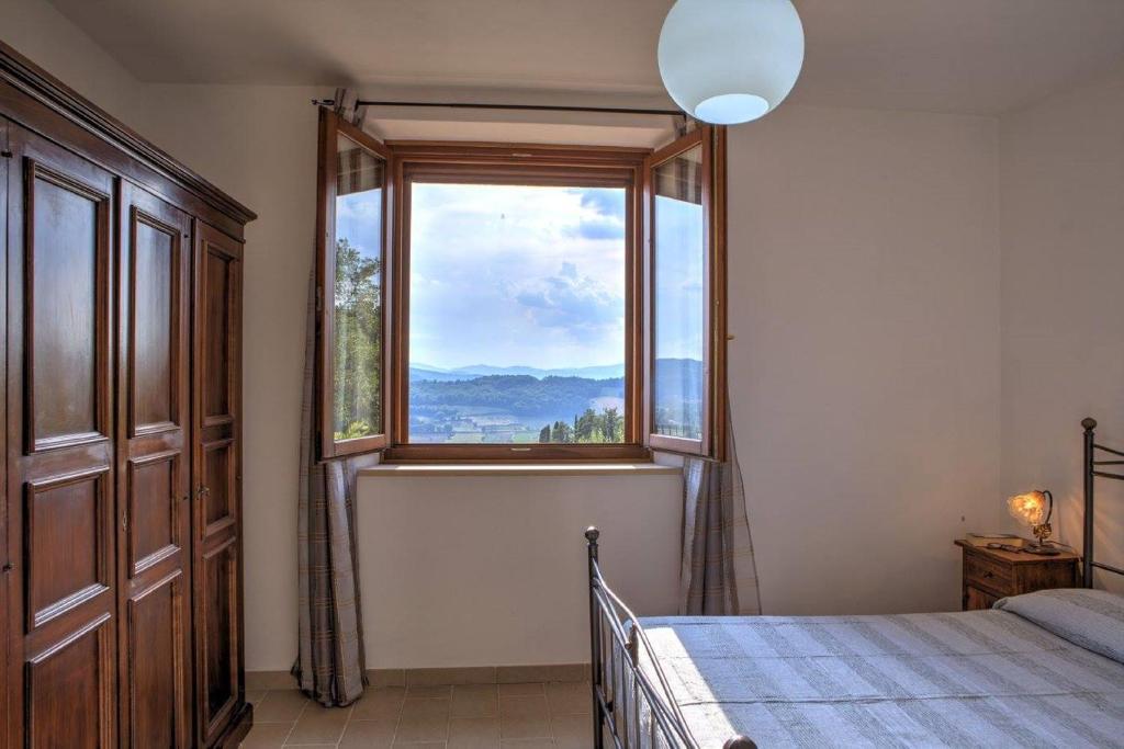 une chambre avec un lit et une grande fenêtre dans l'établissement Villa Morotti by Mmega, à Montone