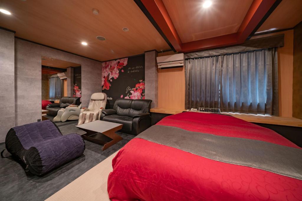 - une chambre avec un lit rouge et un salon dans l'établissement 飛騨高山 ホテル デリッシュ, à Takayama