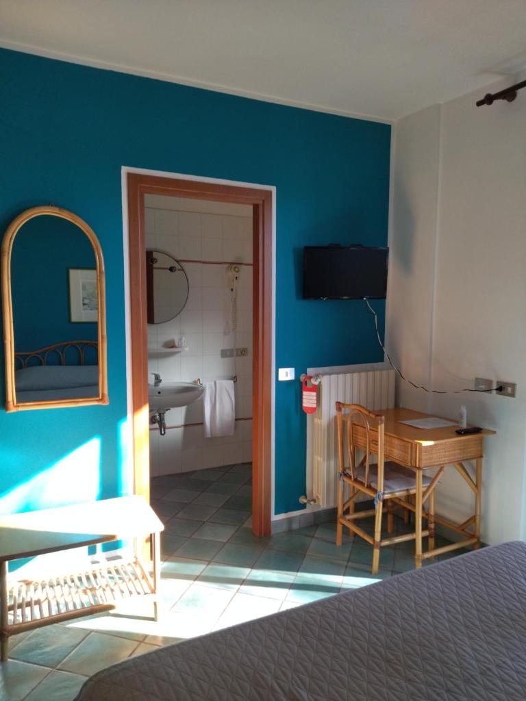 une chambre avec un lit et une table et une salle de bain dans l'établissement Albergo Il Biancospino, à Sirmione