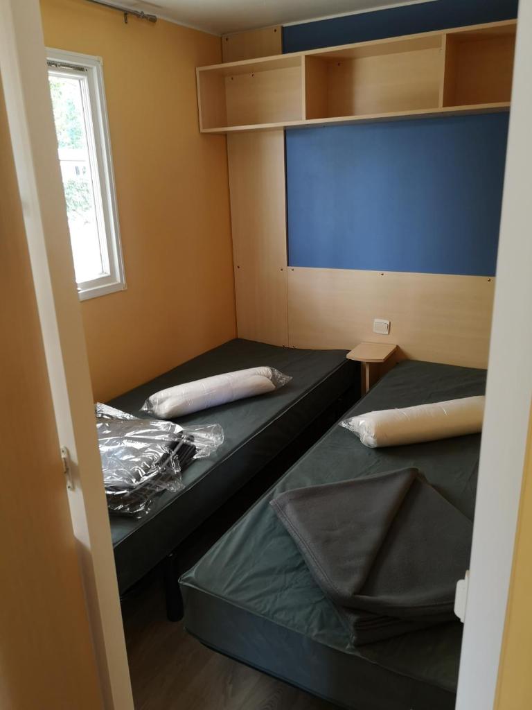 Cette petite chambre comprend 2 lits et un écran. dans l'établissement Mobil-home 6 pers Coeur de Vendée, à Le Pont Legé