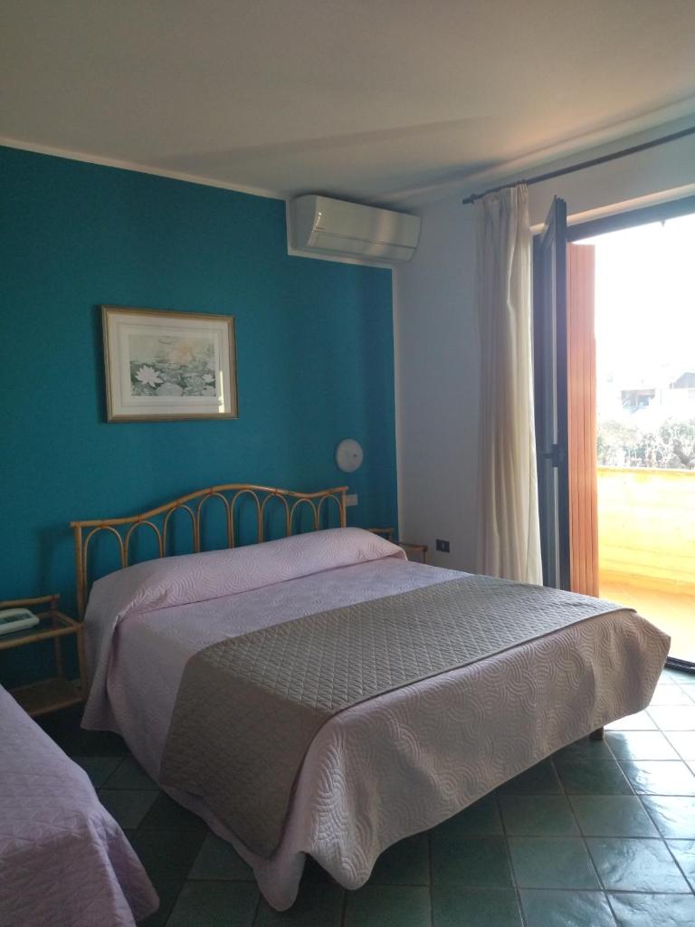 une chambre avec un lit avec un mur bleu dans l'établissement Albergo Il Biancospino, à Sirmione